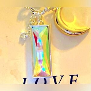 This beautiful new necklace has a reflective gemstone & charm of the moo…